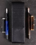 Two Pelikan (Germany) '200' piston filing fountain pens: one on smoked amber,