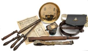 A collection of various militaria: comprising a brown leather belt with a collection of cap badges