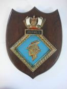 A ward room badge for HMS Hermes on wooden shield plinth: 33cm high.