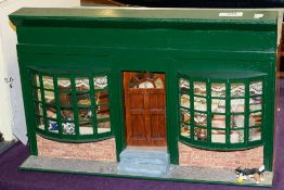 A 20th Century doll's tea shop with green double bay window front, interior figures,