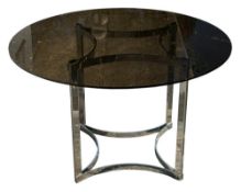 A smoked glass circular dining table on stainless steel base: with concave stretchers to top and