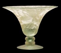 An art glass vase: the pale green body of flaring form set on a short knopped stem and domed foot,