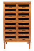 A mid 20th Century beech haberdashery cabinet:, of two flights of eight glazed drawers,