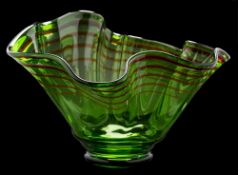 A large 'Venetian' glass bowl: possibly by Bob Crooks, the green glass body with wavy rim,