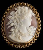An oval shell cameo portrait brooch: depicting a classical woman, within a circular-link frame,