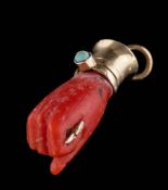 A coral mounted figa pendant: approximately 24mm long, 3gms gross weight.