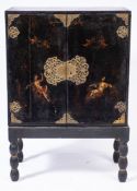 An 18th Century Italian black lacquer and decorated cabinet on a later stand:,