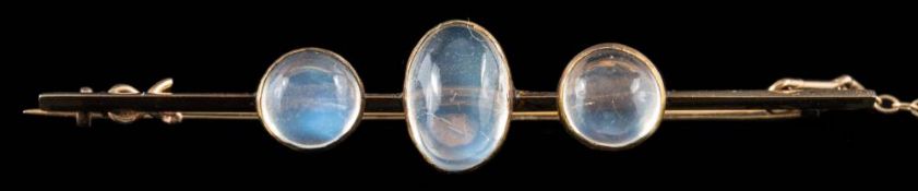 A moonstone three-stone bar brooch: set with an oval moonstone between circular moonstones,