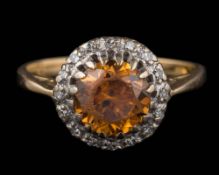 An 18ct gold, orange zircon and diamond circular cluster ring:, ring size K.