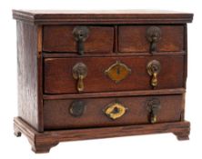 An antique miniature oak chest: of rectangular outline containing two short and two long drawers on