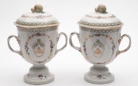 A pair of Chinese famille rose two-handled pedestal urns and covers: each with entwined branch