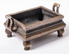 A Chinese bronze censer: of rectangular archaistic form with pierced s-shaped handles,