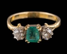 An emerald and diamond three-stone ring: the rectangular emerald set between old-cut diamonds,