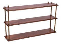 A Victorian mahogany three tier hanging bookshelf: with brass turned uprights and moulded shelves.