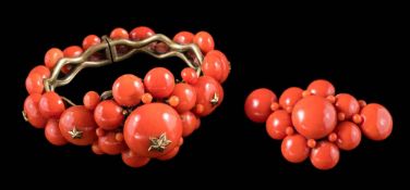 An antique coral and gilt metal hinged bangle: set with graduated coral beads set with star motif
