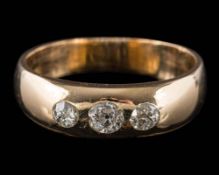 A gold and three-stone diamond band: with graduated old-cut diamonds estimated to weigh a total of