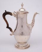 A late Victorian silver coffee pot, maker's mark worn, London 1898: crested, of ovoid form,