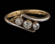 An 18ct gold and diamond mounted three-stone cross-over ring: set with graduated diamonds in
