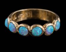 A 9ct gold and simulated opal six-stone ring: of hammered design,