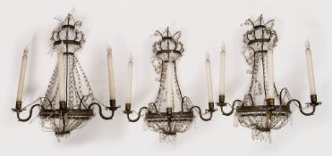 A set of three late 19th century brass and glass lustre three -branch wall lights: of bow-fronted
