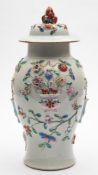 A Chinese famille rose relief-decorated baluster jar and cover: applied with baskets, vases,