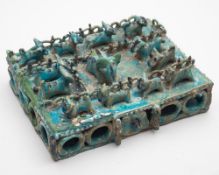 An unusual turquoise glazed tile: probably Iranian modelled in the form of a fenced rectangular