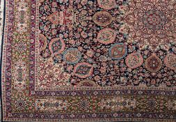 A Kirman carpet:, the indigo field with a main ivory geometric flowerhead medallion,