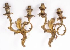 A pair of gilt metal twin-branch wall lights: in the rococo style,