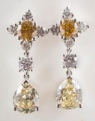 A pair of fancy yellow and white diamond drop earrings: each set with a fancy yellow and white