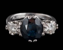 An 18ct white gold, sapphire and diamond three-stone ring: the oval sapphire approximately 9.