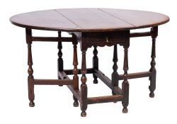 An 18th Century oak oval gateleg table:, with a hinged top and frieze drawer to either end,