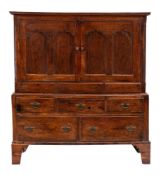 An 18th Century oak side cupboard:, in two parts, with a reeded cornice,