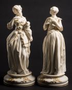 A pair of Continental white and gilt parian figures: in the form of elegant ladies,