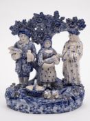 A Staffordshire blue and white pottery tithe pig group: of conventional form with bocage background
