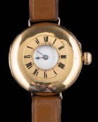 An 18ct gold half hunter wristwatch: the white enamelled dial with Roman numerals,