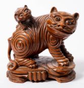 A Chinese carved wood lion dog: standing on all fours with a young pup on its back,
