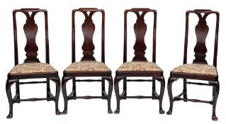 A set of four George II mahogany dining chairs: the curved backs with shaped toprails and pierced