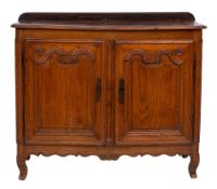 An 18th Century French provincial oak buffet:, the top with a moulded edge and rounded corners,