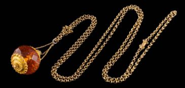 A mid 19th century gold mounted amber bead 'smelling salts' pendant: the faceted amber bead
