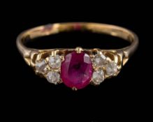 A ruby and diamond cluster ring: the central, oval ruby approximately 5.8mm long x 4.