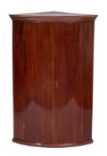 An 18th Century mahogany bow-fronted hanging corner cupboard:,