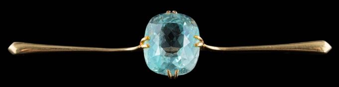 An aquamarine single-stone bar brooch: the cushion-shaped aquamarine approximately 13.5mm long x 11.