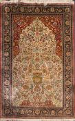 A Tabriz silk prayer rug:, the ivory mihrab with an all over design of flowers,