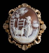 A late 19th century gold and shell cameo brooch: depicting a shepherdess with sheep in a gateway