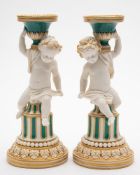 A pair of Minton coloured parian 'Putti' candlesticks: decorated in green enamels and gilt,