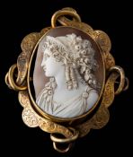 A Victorian oval shell cameo brooch: within a foliate engraved openwork scroll frame approximately