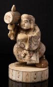 A Japanese sectional ivory okimono of Daikoku: holding his mallet,