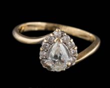 An 18ct gold and diamond cluster ring: the central pear-shaped diamond approximately 6.8mm long x 4.