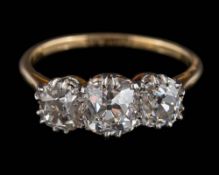 A diamond three-stone ring: set with cushion-shaped old brilliant-cut diamonds the central diamond