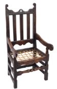 A late 17th Century oak open armchair:, the back with shaped top rail and pierced centre,